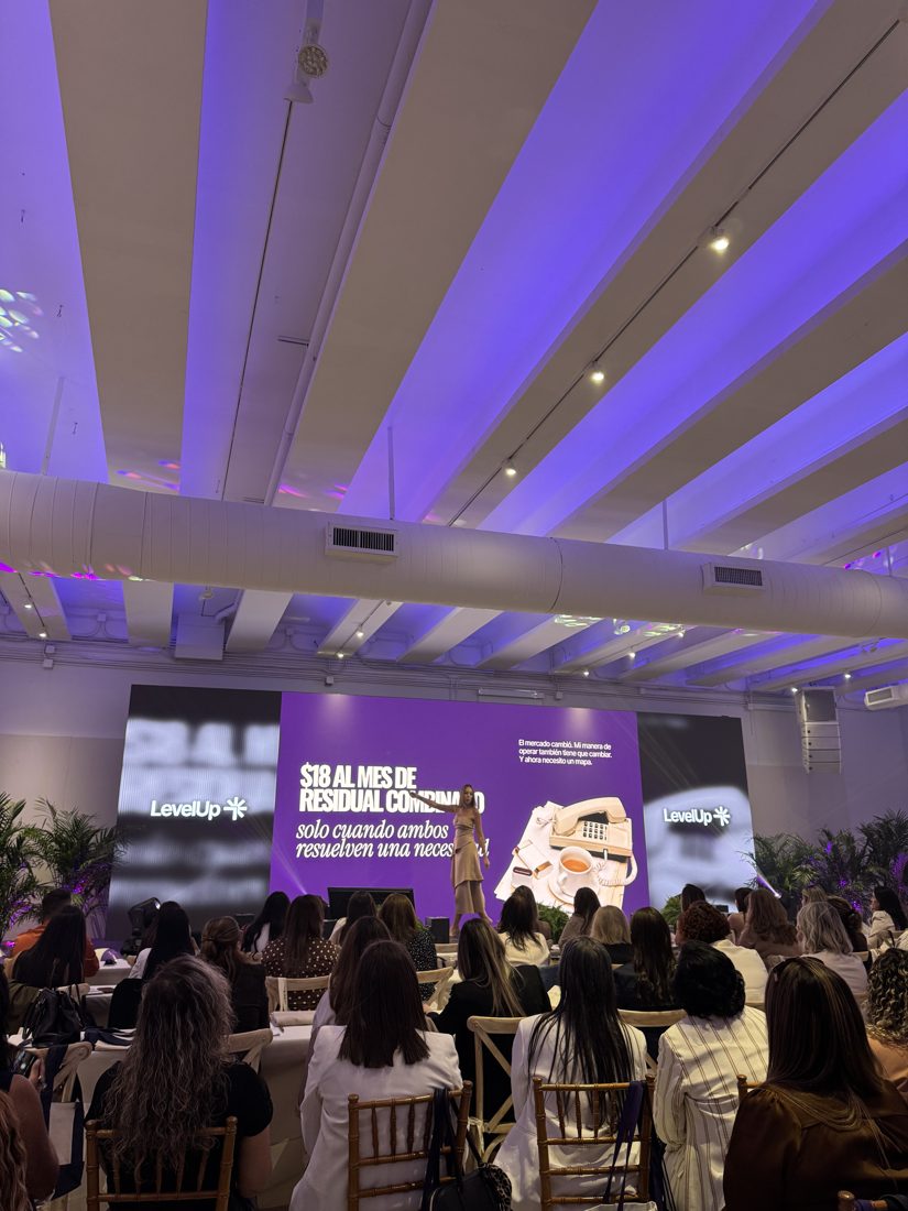 LED wall behind a speaker at a conference with a seated audience